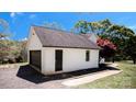 Detached white brick garage with a black door and gravel driveway at 3032 Mckinney Rd, Shelby, NC 28152