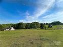 Expansive green field showcasing the property with a distant house and barn at 3032 Mckinney Rd, Shelby, NC 28152