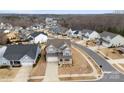 Beautiful aerial view of a gray home nestled in a quiet neighborhood by the lake with mature trees at 3041 Winged Teal Ct, Belmont, NC 28012