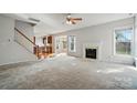 Bright living room with a fireplace, adjacent to the kitchen, features neutral colors and large windows at 3619 Grove Creek Pond Sw Dr, Concord, NC 28027