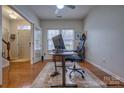 Bright home office with hardwood floors, natural light, and a modern adjustable standing desk setup at 4011 Fenworth Ct, Fort Mill, SC 29715