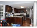 Kitchen with dark cabinets, an island, stainless steel appliances, and hardwood floors at 5915 Bluebonnet Rd, Charlotte, NC 28212