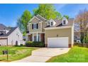 Charming two-story home boasts well-manicured lawn, brick accents, and attached garage under bright blue skies at 609 Tysons Forest Dr, Rock Hill, SC 29732
