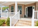 Inviting front porch featuring brick steps, white railings, and a stylish black front door at 620 Baneberry Bluff Ct, Rock Hill, SC 29732