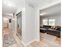 Bright hallway with modern flooring, leading to the living area and bathroom at 6310 Welford Rd, Charlotte, NC 28211