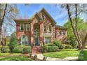 Charming brick home with arched entry, well-maintained lawn, and mature trees at 7117 Chadwyck Farms Dr, Charlotte, NC 28226