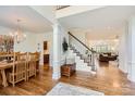 Bright foyer with hardwood floors, staircase, dining area, and a view of the living room at 7316 Versailles Ln, Charlotte, NC 28277