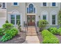 Elegant entryway with brick steps, double doors with wreaths, and manicured landscaping at 7316 Versailles Ln, Charlotte, NC 28277