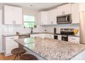 Modern kitchen with white cabinetry, subway tile backsplash, stainless steel appliances, and a granite-topped island at 803 E 13Th St, Kannapolis, NC 28083