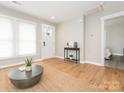 Bright living room featuring wood floors, neutral walls, large windows, and a decorative console table near the front door at 803 E 13Th St, Kannapolis, NC 28083