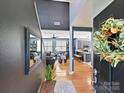 Bright foyer showcasing hardwood floors, modern lighting, and views into the living room and kitchen at 8140 Laurel Run Dr, Charlotte, NC 28269