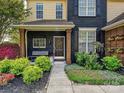 Beautiful home featuring a black painted brick and tan siding with colorful landscaping along the walkway at 8140 Laurel Run Dr, Charlotte, NC 28269