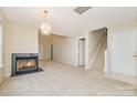 Spacious living room featuring a cozy fireplace and staircase to the upper level at 942 Pelican Bay Dr, Pineville, NC 28134