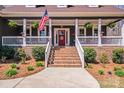Inviting front porch showcasing a red door, white railings, and brick stairs at 1016 Secretariat Dr, York, SC 29745