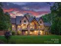 Expansive backyard view showcasing the multi-story home with wood and stone elements and a covered patio at 10723 Green Heron Ct, Charlotte, NC 28278