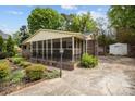 Side view of the charming brick home with a screened-in back porch and a long driveway at 1113 Urban Pl, Charlotte, NC 28209
