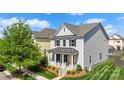 Inviting two-story home displays a charming front porch and manicured lawn at 13813 Jacks Ln, Pineville, NC 28134