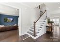 Elegant foyer showcasing hardwood floors, a staircase with white railings, and a view into the living room at 13813 Jacks Ln, Pineville, NC 28134