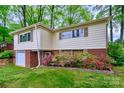 Charming home with brick accents, flowering shrubs, and green lawn, creating a welcoming exterior at 1409 Sherwood Dr, Kannapolis, NC 28081