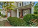 Welcoming front porch with brick and siding accents, flowering bushes and charming decor at 16524 Kettlewell Ln, Charlotte, NC 28277