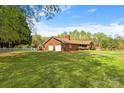 Spacious brick home boasts an expansive green lawn, a detached garage, and a charming white picket fence at 173 Chestnut Grove Rd, Statesville, NC 28625