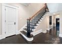 Elegant staircase with dark wood steps, ornate black railings, and a contrasting light wall color at 2030 Radcliffe Ave, Charlotte, NC 28207