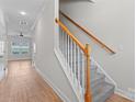 Welcoming entryway with hardwood floors, staircase with carpeted steps and views to living area at 2032 Summey Ave, Charlotte, NC 28205