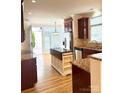 Bright kitchen with granite counters, stainless appliances, wood floors, and center island at 216 Harrison Ln # 4, Locust, NC 28097
