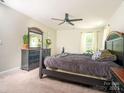 Cozy bedroom with dark furniture, a ceiling fan, carpeted floors, and ample natural light at 2313 Glenwood St, Kannapolis, NC 28083