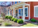 Cozy front porch with rocking chairs, decorative wreath, and well-maintained landscaping at 2329 Paddlers Cove Dr, Clover, SC 29710