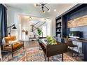 Stylish home office featuring custom built-ins, a modern desk, and comfortable seating area at 2329 Paddlers Cove Dr, Clover, SC 29710