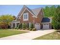 Side view of brick and stone home showing attached garage and driveway at 2610 Creek Manor Dr, Waxhaw, NC 28173
