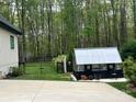 View of the backyard with well kept lawn, greenhouse, and fenced in area at 2656 Lee Lawing Rd, Lincolnton, NC 28092