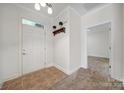 Inviting foyer with tile flooring, coat rack, and neutral paint at 2959 Bellasera Way, Matthews, NC 28105
