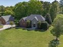 Sprawling estate featuring a brick and stone home, detached garage, and expansive green lawn at 3677 Antioch Church Rd, Matthews, NC 28104