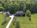 Overhead view of a large property with a pool, detached garage, long driveway, and lush trees at 3677 Antioch Church Rd, Matthews, NC 28104