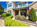 Inviting front porch with rocking chairs, flowering bushes, and an American flag, creating a warm welcome at 4032 Wild Turkey Ln, Indian Land, SC 29707