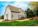 Expansive backyard with a charming brick patio, deck, hot tub, fire pit, and lush lawn at 4205 Green Park Ct, Harrisburg, NC 28075
