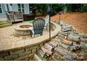 Inviting backyard seating area with custom stone fire pit, perfect for relaxing evenings at 4205 Green Park Ct, Harrisburg, NC 28075