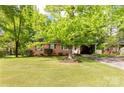 Quaint single story brick home showcasing a lovely lawn and a carport surrounded by lush greenery at 510 N Jackson Rd, Lancaster, SC 29720