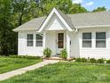 A charming front porch with wood door, fresh landscaping and white painted columns at 512 Secrest Ave, Belmont, NC 28012
