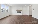 Open-concept living room featuring modern fireplace and neutral color palette at 561 Mountain View Dr, Monroe, NC 28110