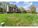 Inviting brick home featuring a well-manicured lawn, lush landscaping, and mature trees at 591 Highland Ridge Rd, Mooresville, NC 28115