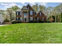 Traditional brick home with well-maintained lawn, blue shutters and mature trees at 591 Highland Ridge Rd, Mooresville, NC 28115