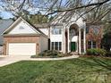 Charming two-story home featuring a brick facade, white columns, a green front door, and a well-maintained lawn at 6112 Swanston Dr, Charlotte, NC 28269