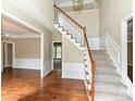 Elegant foyer features hardwood floors, a staircase with carpet runner, and classic wainscoting for a grand entry at 6112 Swanston Dr, Charlotte, NC 28269