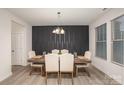 An elegant dining room features a stylish black accent wall, modern chandelier, and a large window at 710 Anglin Forest Way, Charlotte, NC 28214