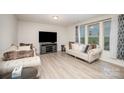 Bright living room with hardwood floors, neutral walls, stylish furnishings, and large window for natural light at 710 Anglin Forest Way, Charlotte, NC 28214