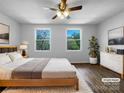 Spacious main bedroom featuring hardwood floors, a ceiling fan, and sunlit windows with green outdoor views at 7301 Pebblestone Dr # F, Charlotte, NC 28212