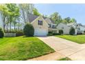 Charming home with a lush green lawn, attached garage, and inviting curb appeal at 7353 Sedgebrook W Dr, Stanley, NC 28164